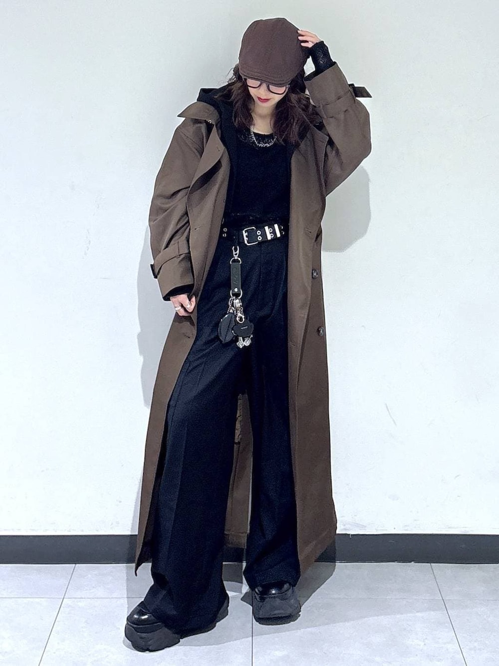 ブラック系のブーツ、ブラウン系のトレンチコート、ブラック系のスラックスを着用したレディースの春コーディネートの3枚目の写真