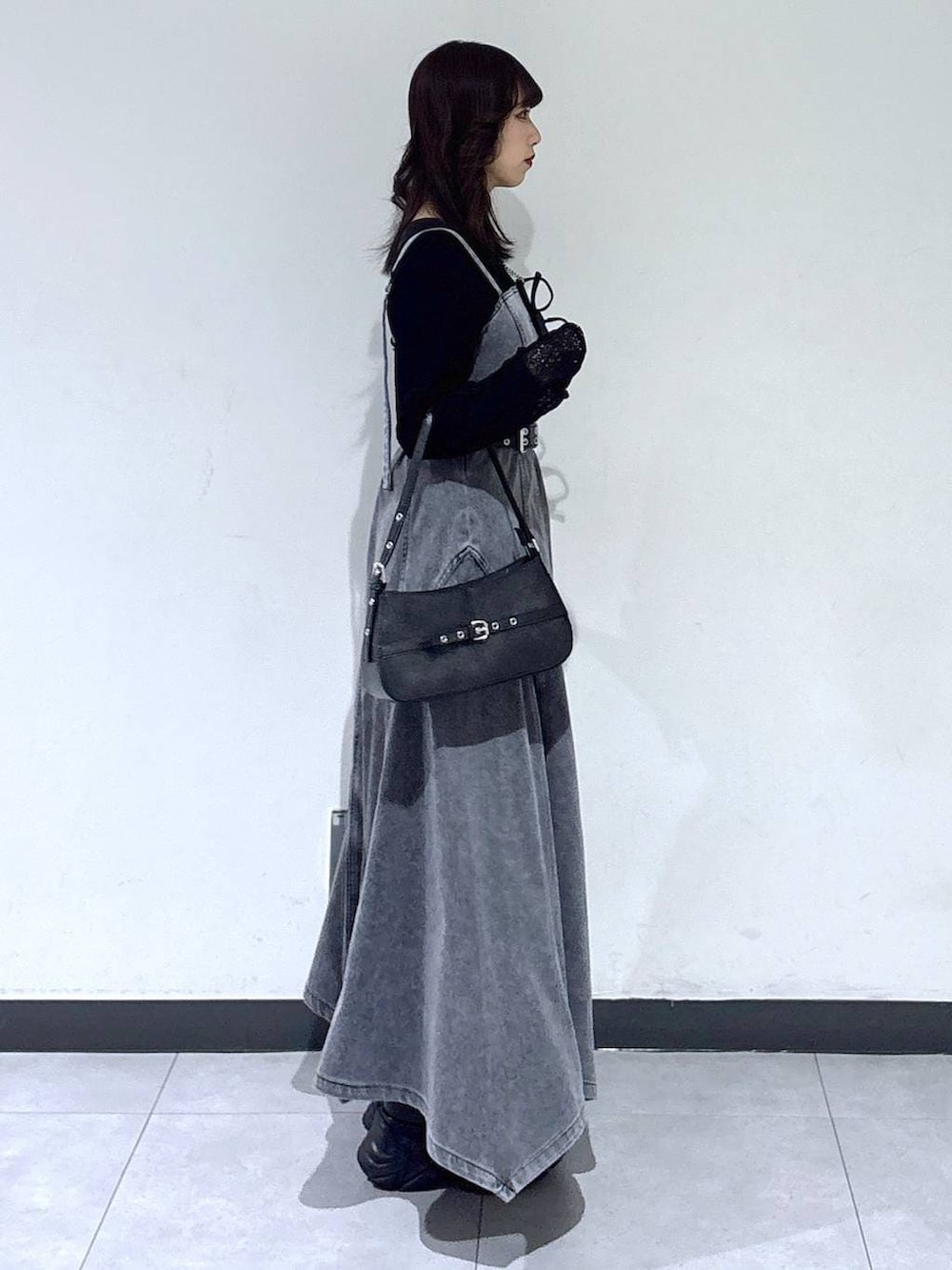 ブラック系のブーツ、ブラック系のTシャツ/カットソー、ブラック系のハンドバッグを着用したレディースの冬コーディネートの5枚目の写真