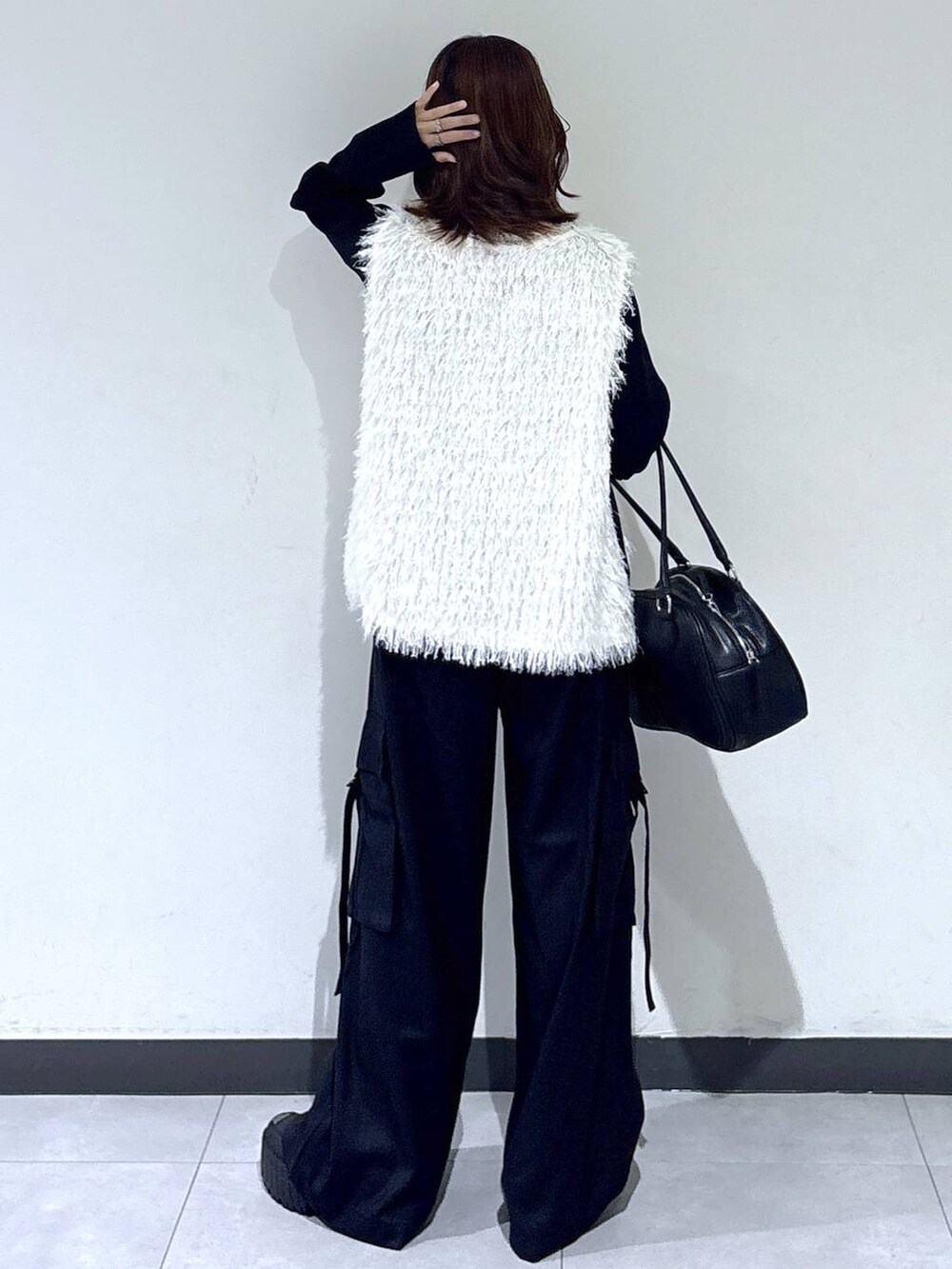 ホワイト系のベスト、ブラック系のTシャツ/カットソー、ブラック系のボストンバッグを着用したレディースの秋コーディネートの7枚目の写真