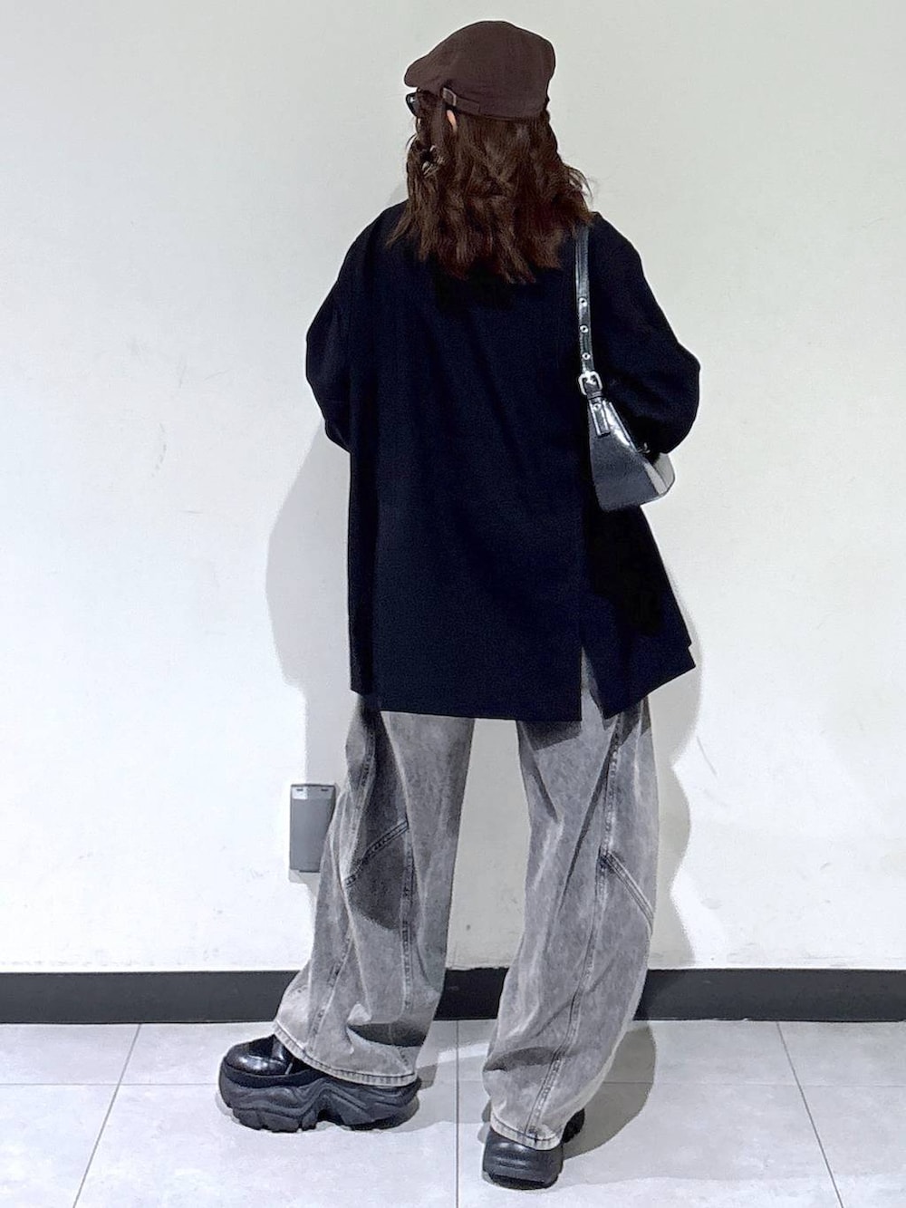 ブラック系のブーツ、ブラック系のハンドバッグ、ブラック系のテーラードジャケットを着用したレディースの春コーディネートの7枚目の写真