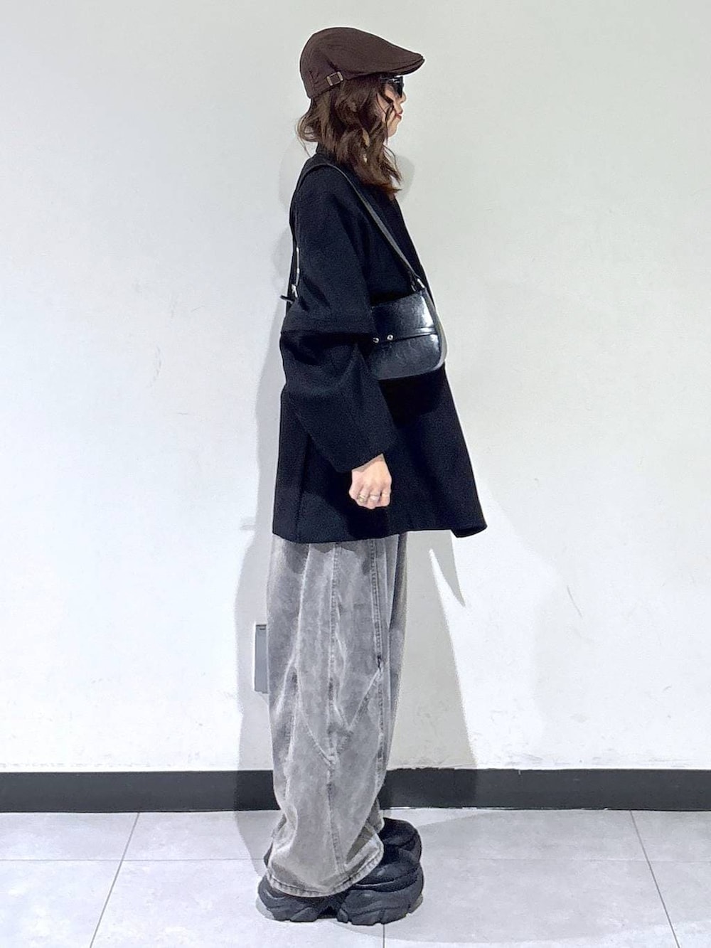 ブラック系のブーツ、ブラック系のハンドバッグ、ブラック系のテーラードジャケットを着用したレディースの春コーディネートの4枚目の写真