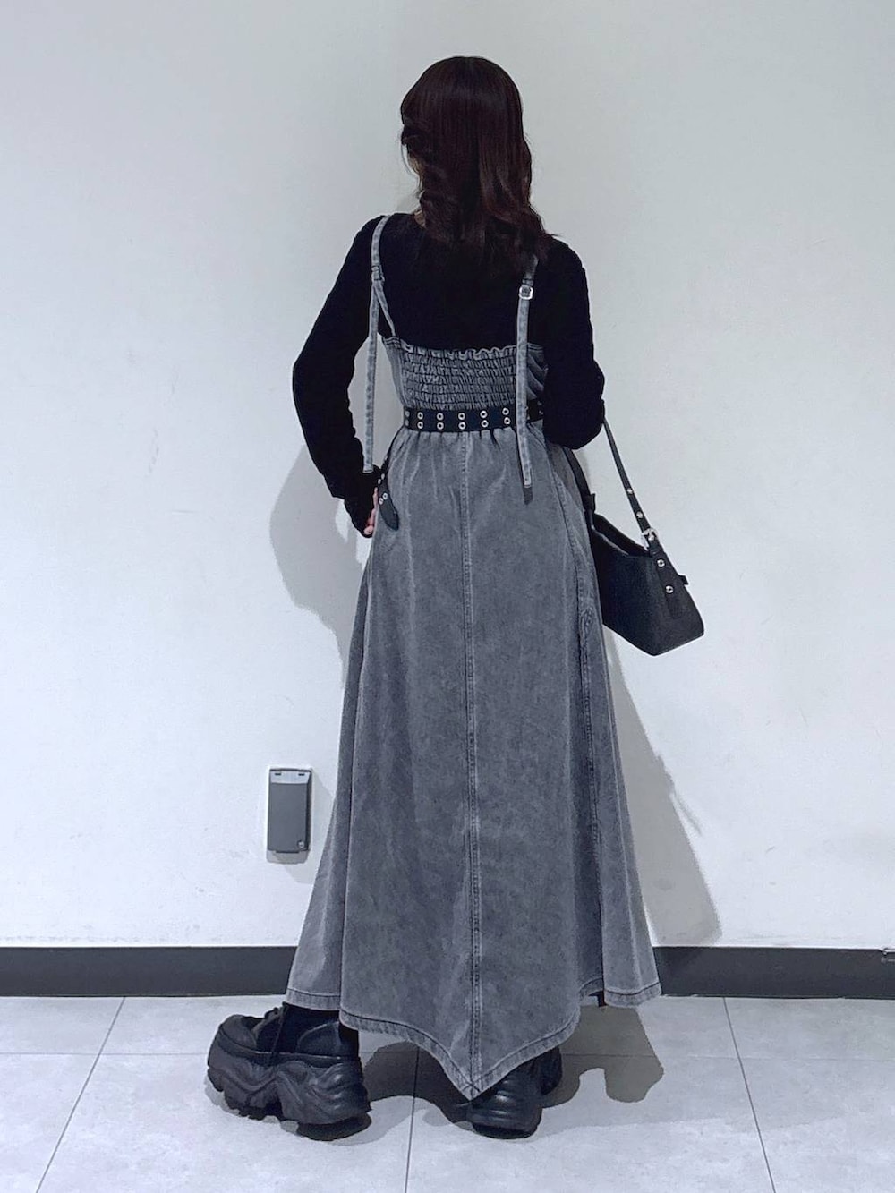 ブラック系のブーツ、ブラック系のTシャツ/カットソー、ブラック系のハンドバッグを着用したレディースの冬コーディネートの7枚目の写真