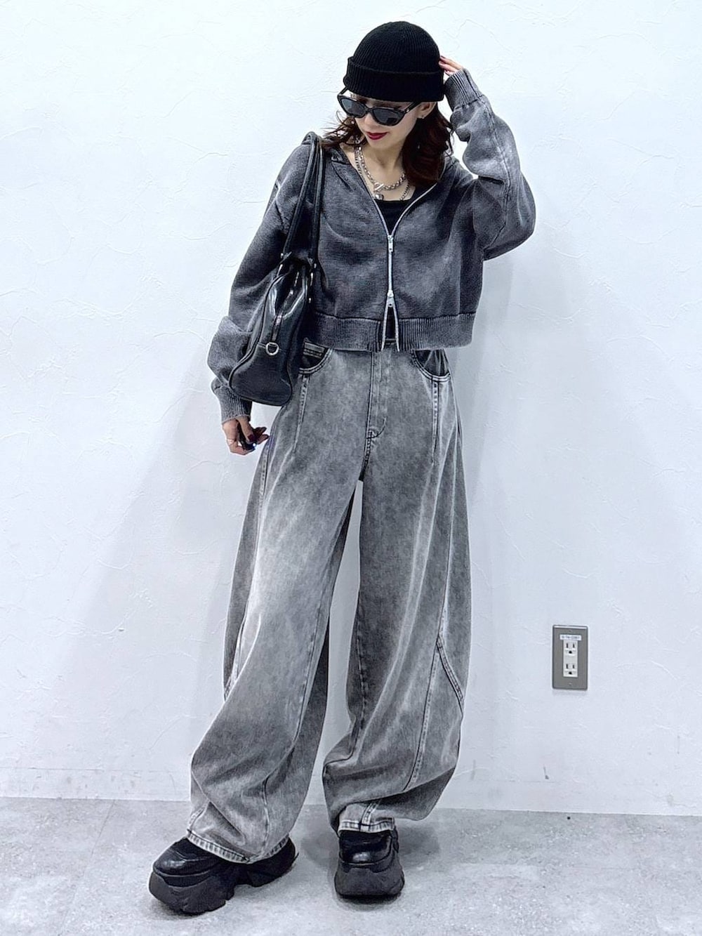 ブラック系のブーツ、ブラック系のボストンバッグ、グレー系のパーカーを着用したレディースの冬コーディネートの3枚目の写真