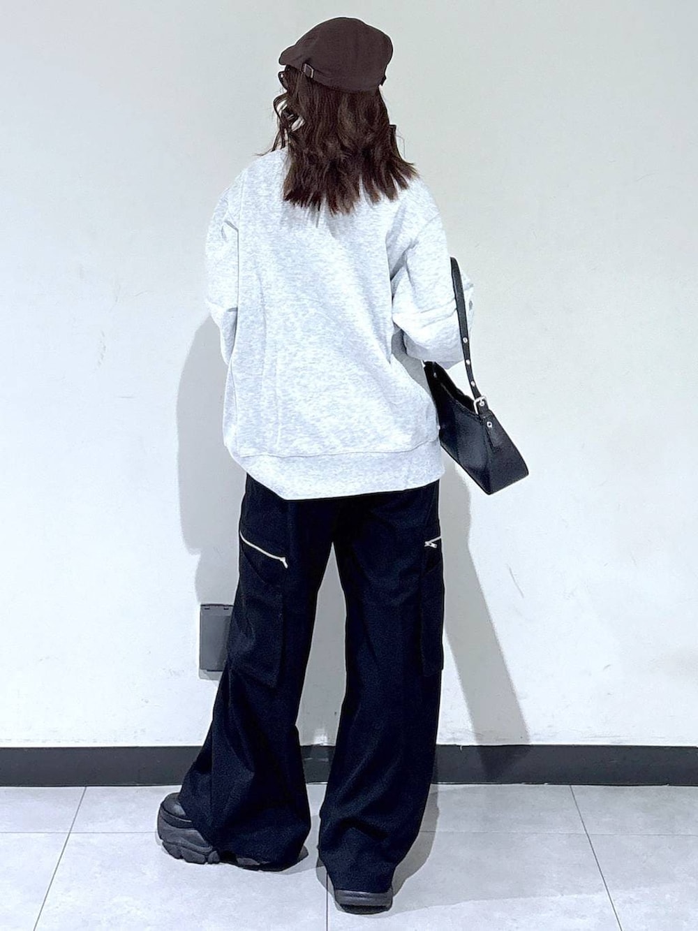 ブラック系のブーツ、グレー系のスウェット、ブラック系のスラックスを着用したレディースの春コーディネートの5枚目の写真