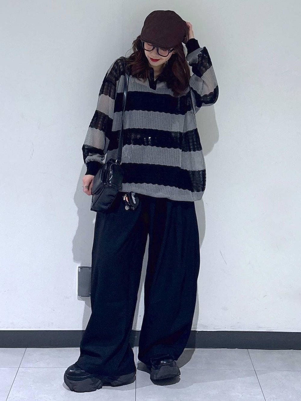 ブラック系のブーツ、ブラック系のスラックス、ブラック系のショルダーバッグを着用したレディースの春コーディネートの5枚目の写真