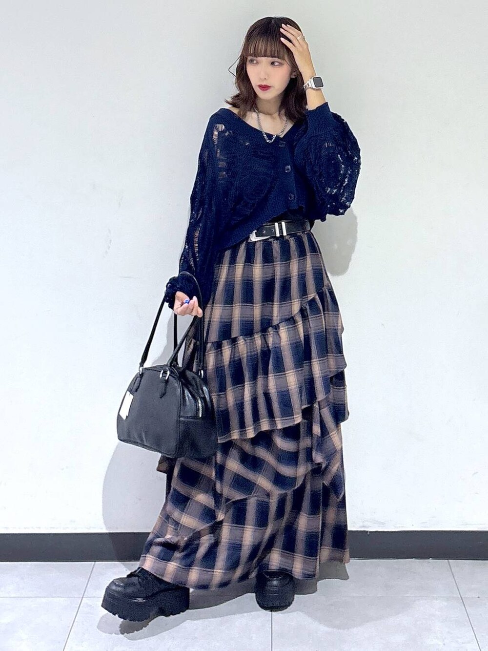 ブルー系のカーディガン/ボレロ、ブラック系のボストンバッグ、ブラウン系のスカートを着用したレディースの秋コーディネートの4枚目の写真