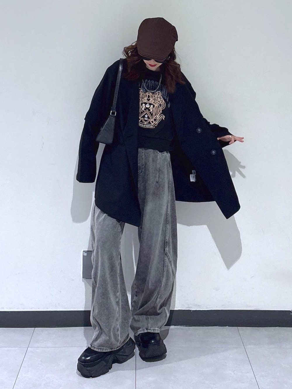 ブラック系のブーツ、ブラック系のハンドバッグ、グレー系のスウェットを着用したレディースの春コーディネートの3枚目の写真