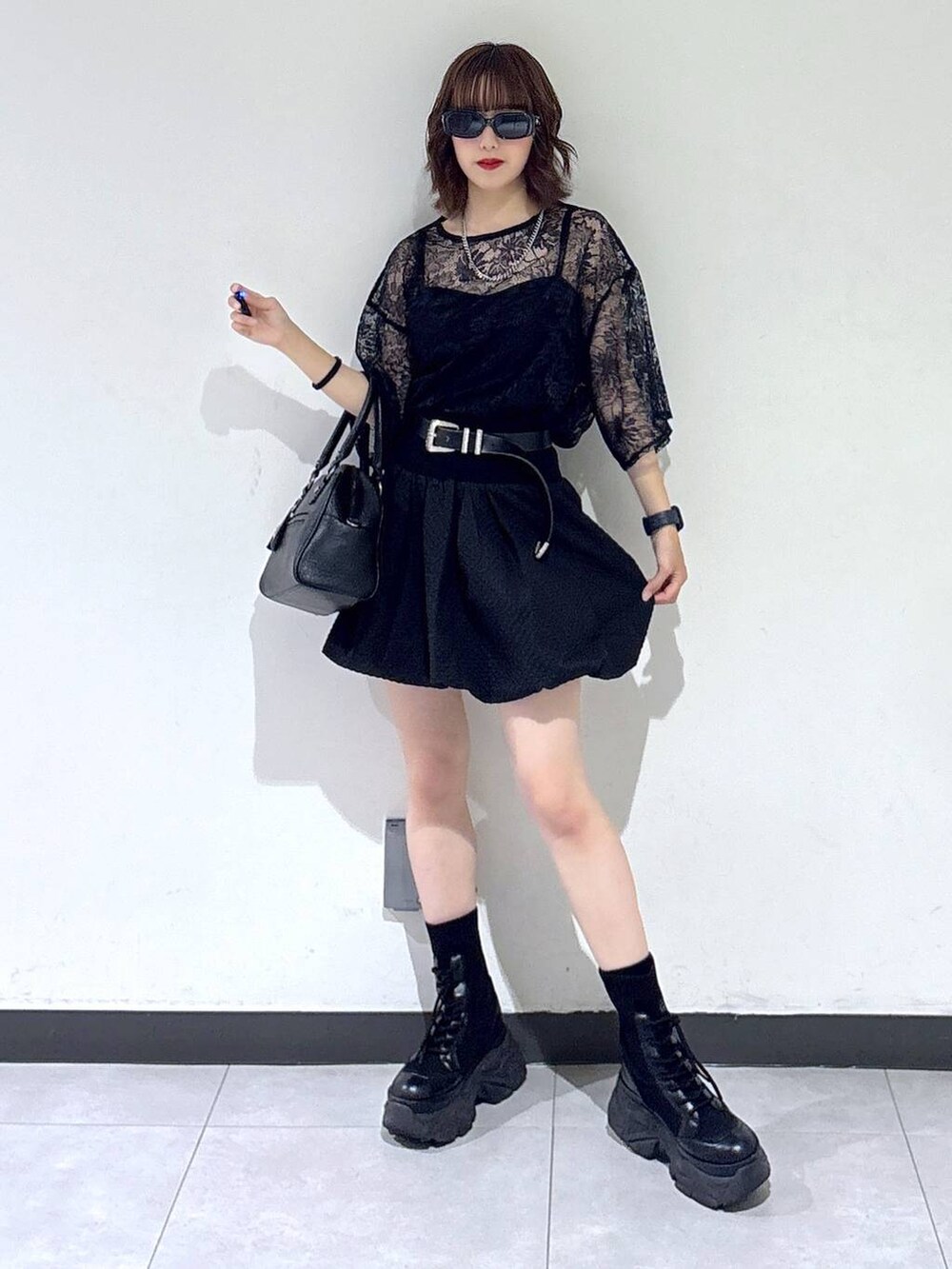 ブラック系のブーツ、ブラック系のTシャツ/カットソー、ブラック系のショルダーバッグを着用したレディースの夏コーディネートの2枚目の写真