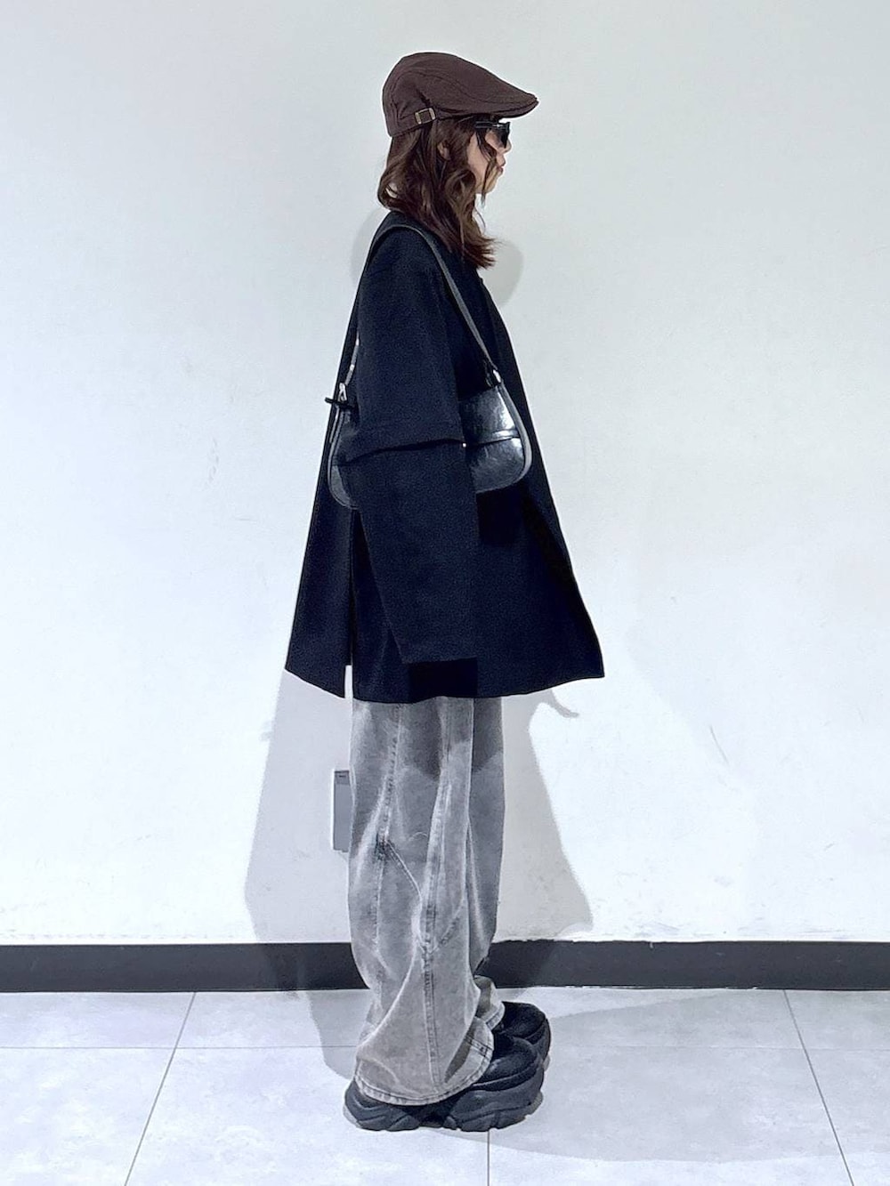 ブラック系のブーツ、ブラック系のハンドバッグ、ブラック系のニット/セーターを着用したレディースの春コーディネートの4枚目の写真