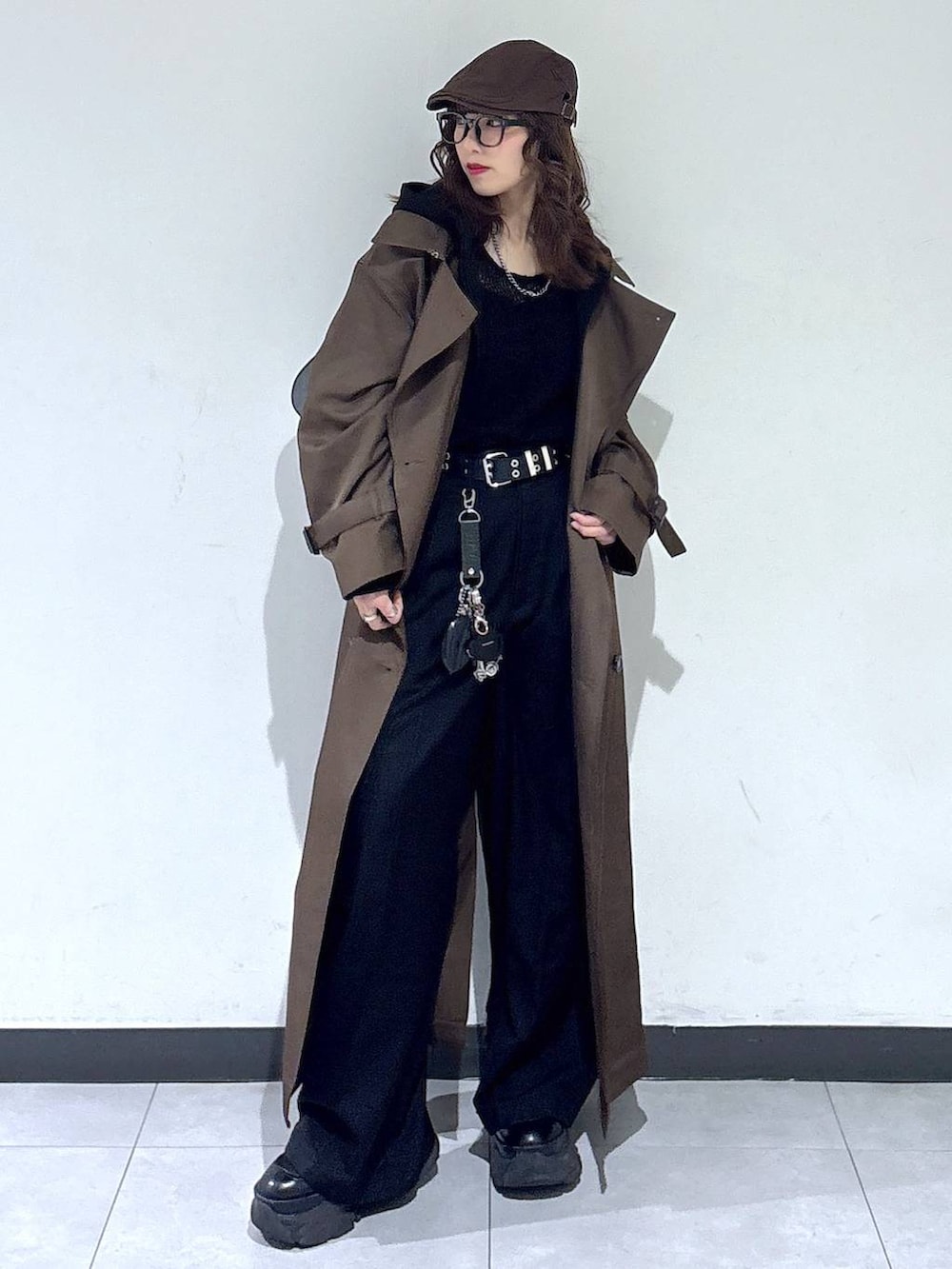 ブラック系のブーツ、ブラウン系のトレンチコート、ブラック系のスラックスを着用したレディースの春コーディネートの5枚目の写真