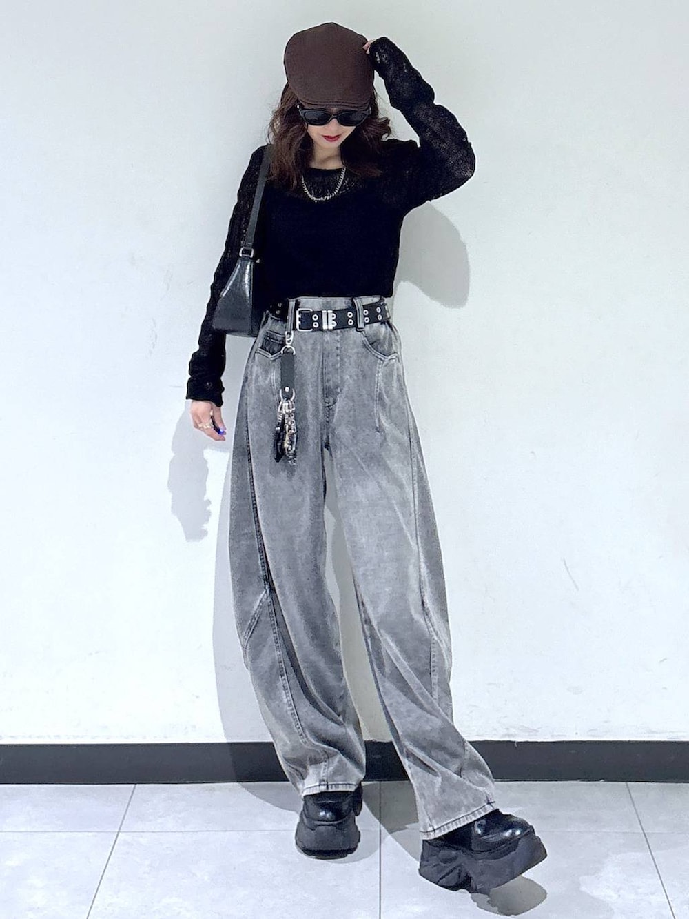 ブラック系のブーツ、ブラック系のハンドバッグ、ブラック系のデニムパンツを着用したレディースの春コーディネートの3枚目の写真