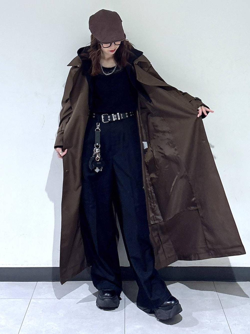 ブラック系のブーツ、ブラウン系のトレンチコート、ブラック系のスラックスを着用したレディースの春コーディネートの4枚目の写真