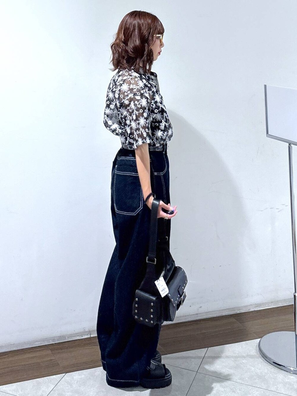 ブラック系のサンダル、ブルー系のデニムパンツ、ブラック系のシャツ/ブラウスを着用したレディースの夏コーディネートの4枚目の写真