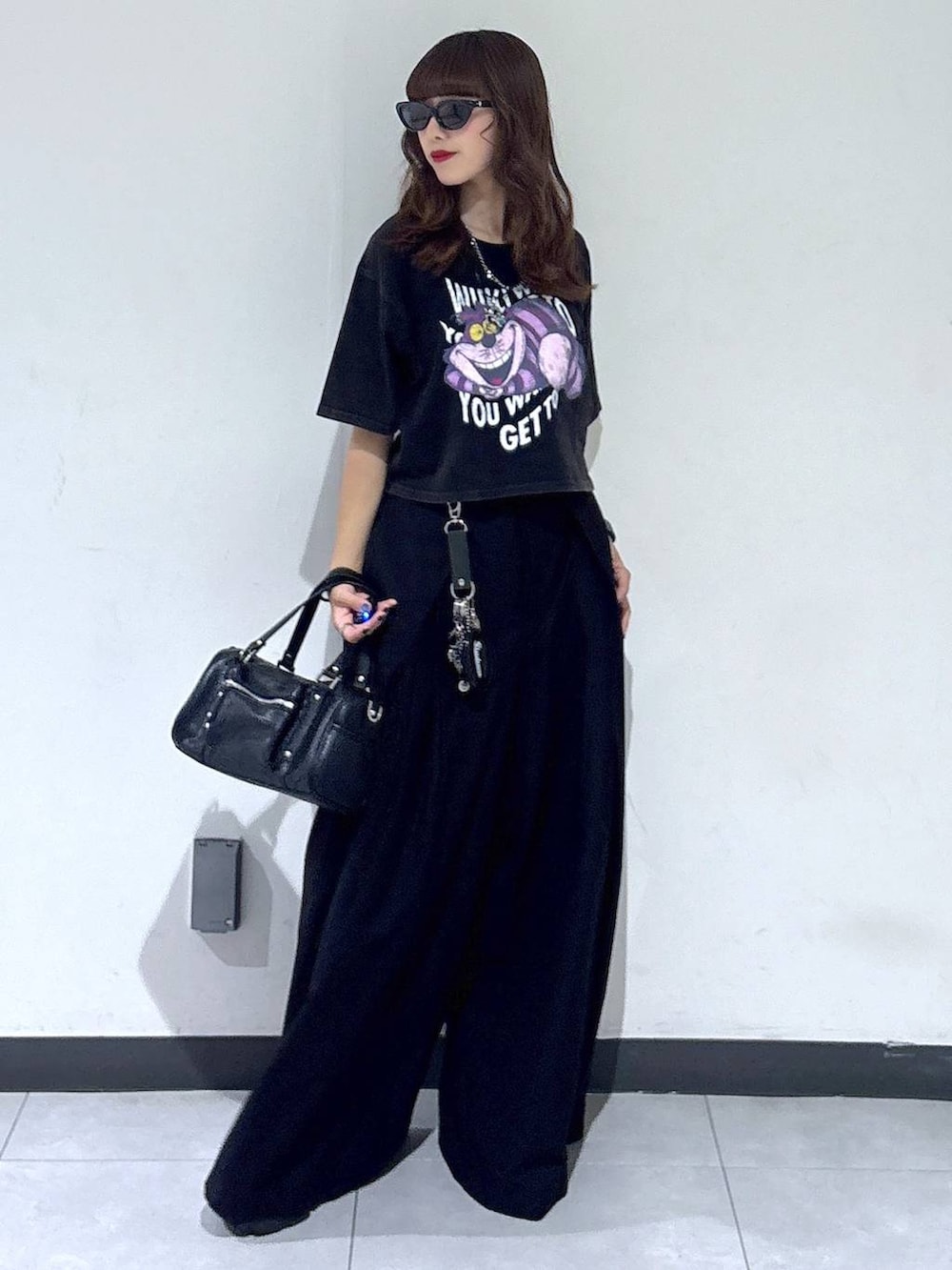 ブラック系のショルダーバッグ、ブラック系のスラックス、グレー系のTシャツ/カットソーを着用したレディースの夏コーディネートの2枚目の写真