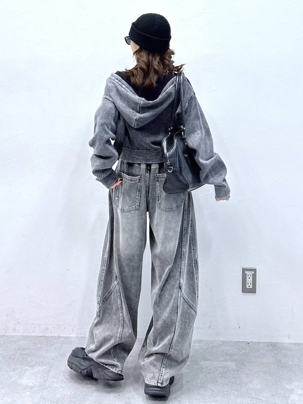 ブラック系のブーツ、ブラック系のボストンバッグ、グレー系のパーカーを着用したレディースの冬コーディネートの5枚目の写真