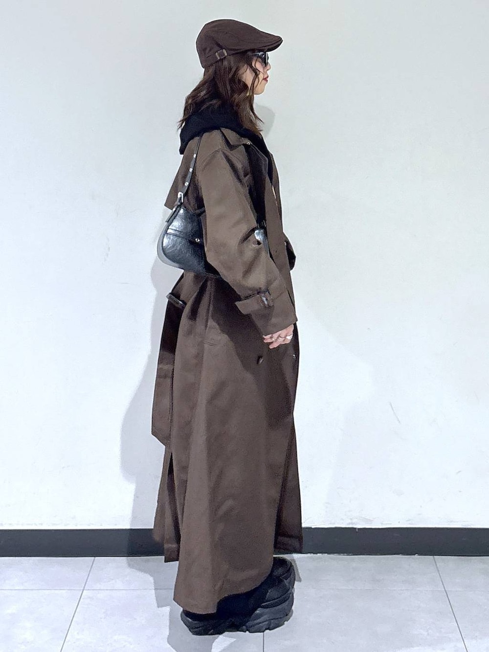 ブラック系のブーツ、ブラウン系のトレンチコート、グレー系のスウェットを着用したレディースの春コーディネートの4枚目の写真