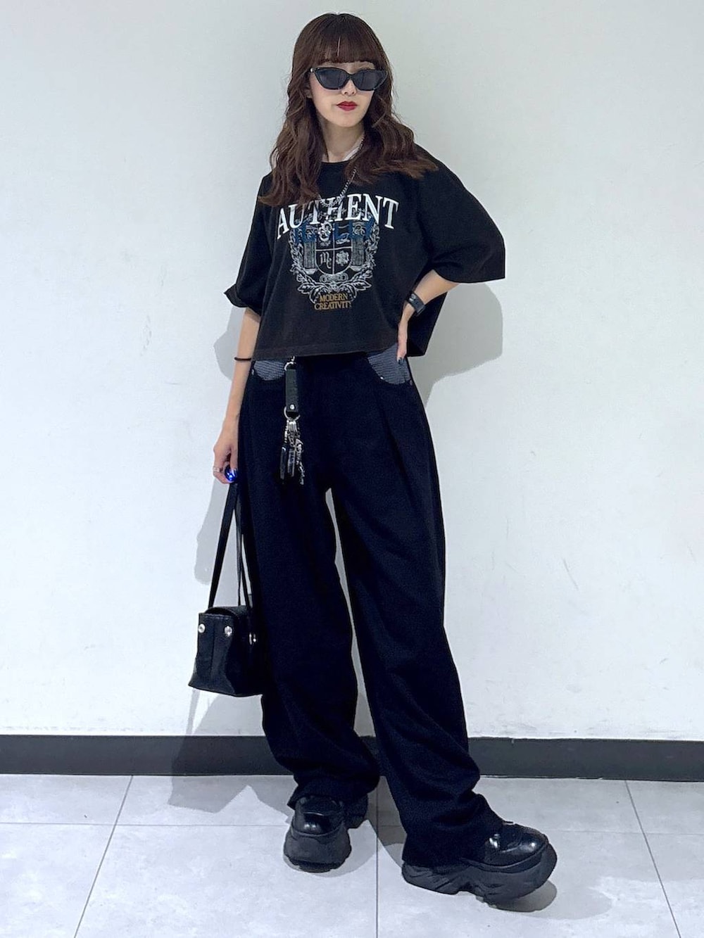 ブラック系のスラックス、グレー系のTシャツ/カットソー、ブラック系のブーツを着用したレディースの夏コーディネートの4枚目の写真