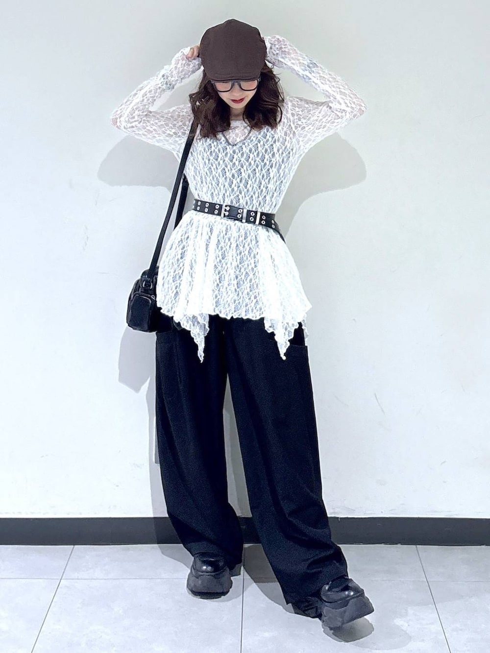 ブラック系のブーツ、ホワイト系のチュニック、ブラック系のショルダーバッグを着用したレディースの春コーディネートの5枚目の写真