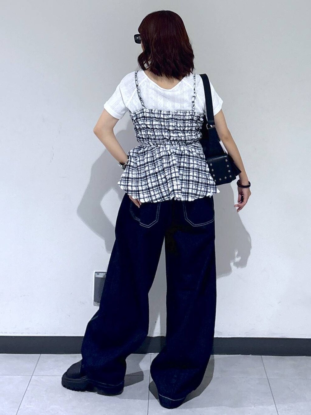 ブラック系のサンダル、ブルー系のデニムパンツ、ブラック系のショルダーバッグを着用したレディースの夏コーディネートの7枚目の写真