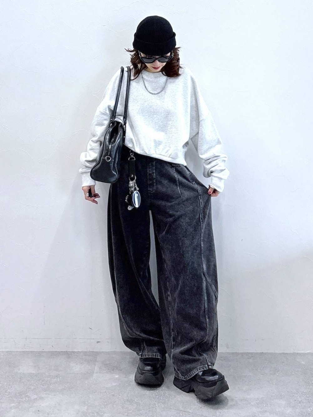 ブラック系のブーツ、ブラック系のボストンバッグ、ブラック系のデニムパンツを着用したレディースの冬コーディネートの3枚目の写真