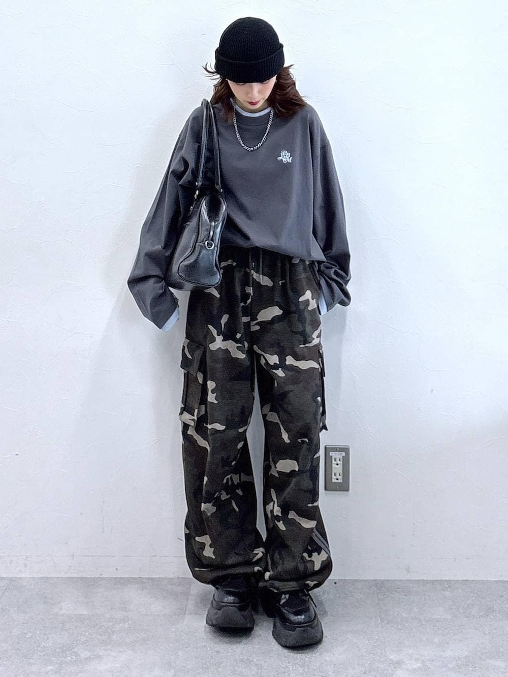 ブラック系のブーツ、ブラック系のボストンバッグ、グレー系のTシャツ/カットソーを着用したレディースの冬コーディネートの6枚目の写真