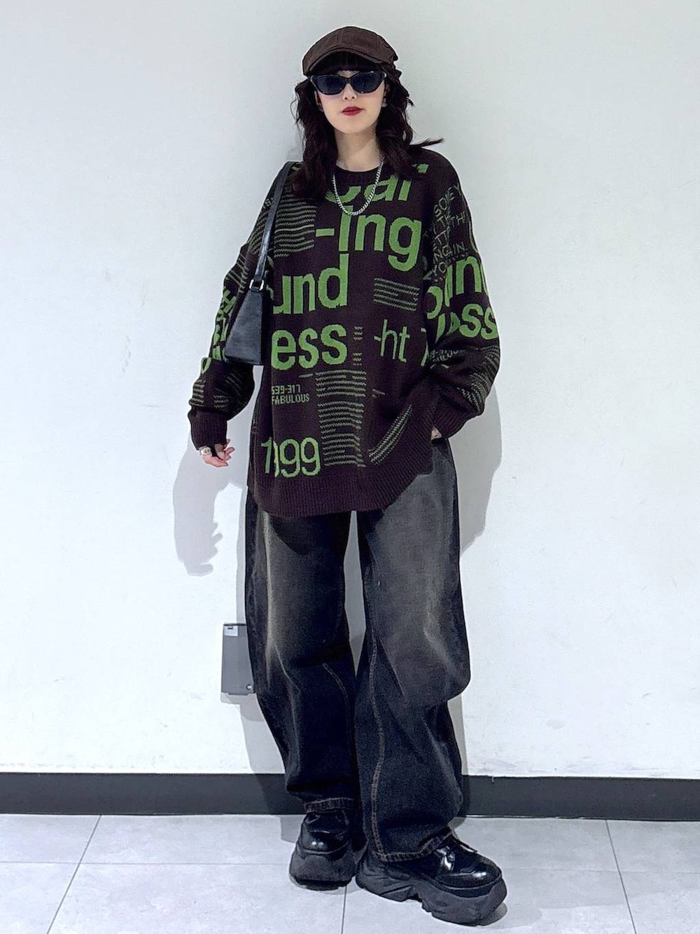 ブラック系のブーツ、ブラック系のデニムパンツ、ブラウン系のニット/セーターを着用したレディースの冬コーディネートの3枚目の写真