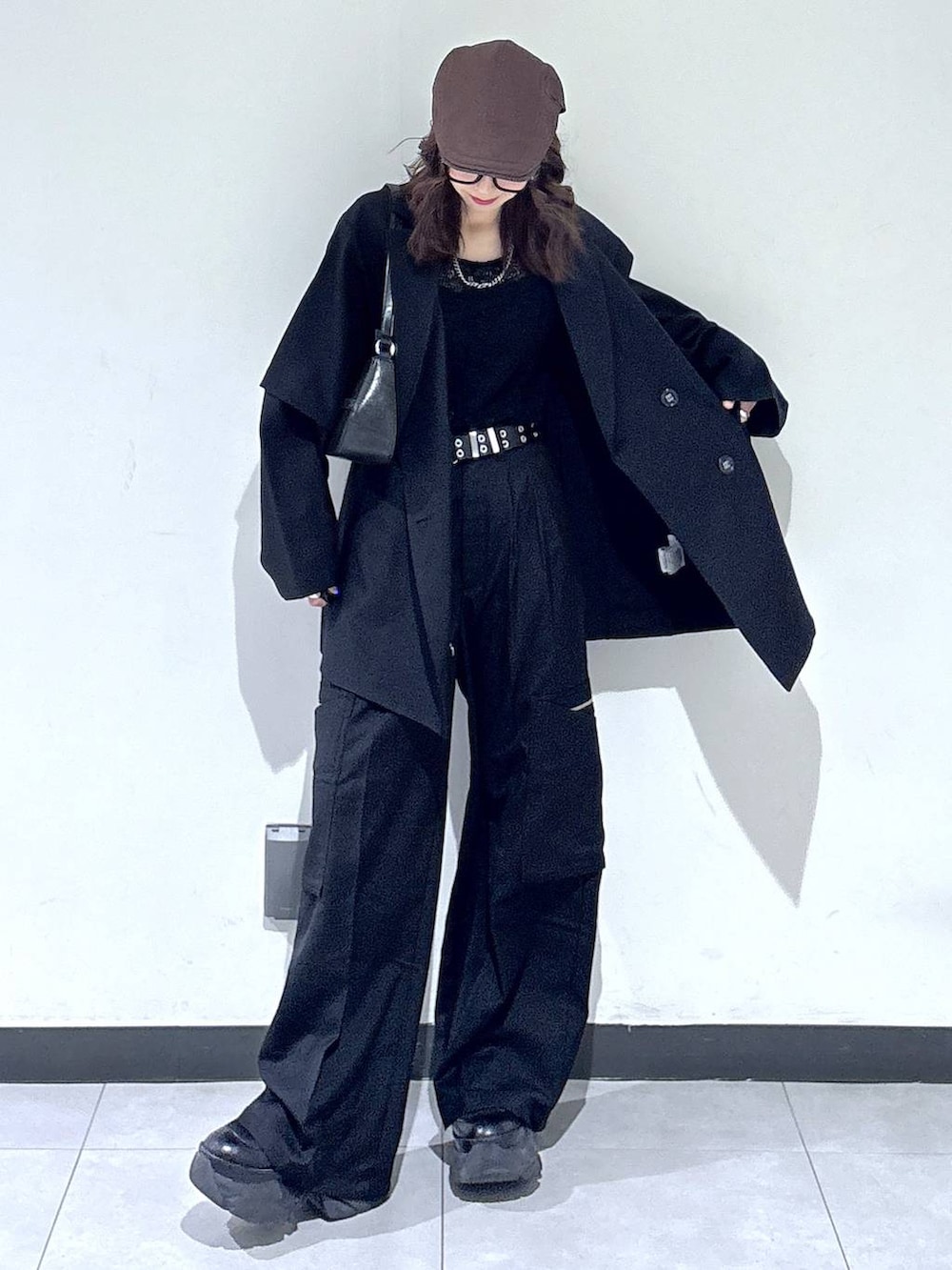 ブラック系のブーツ、ブラック系のハンドバッグ、ブラック系のスラックスを着用したレディースの春コーディネートの4枚目の写真