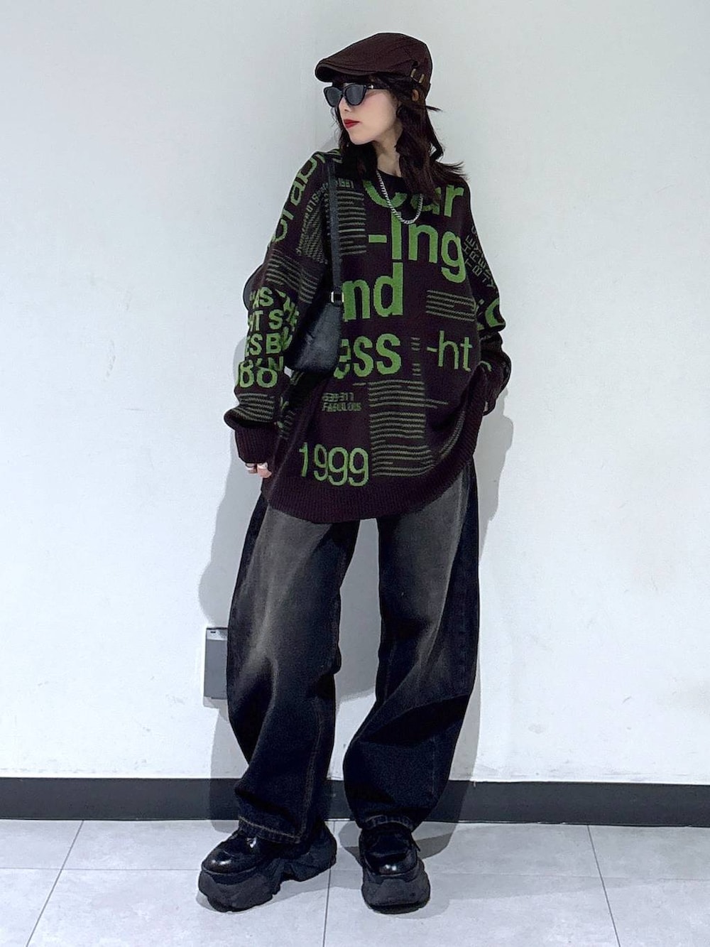 ブラック系のブーツ、ブラック系のデニムパンツ、ブラウン系のニット/セーターを着用したレディースの冬コーディネートの6枚目の写真