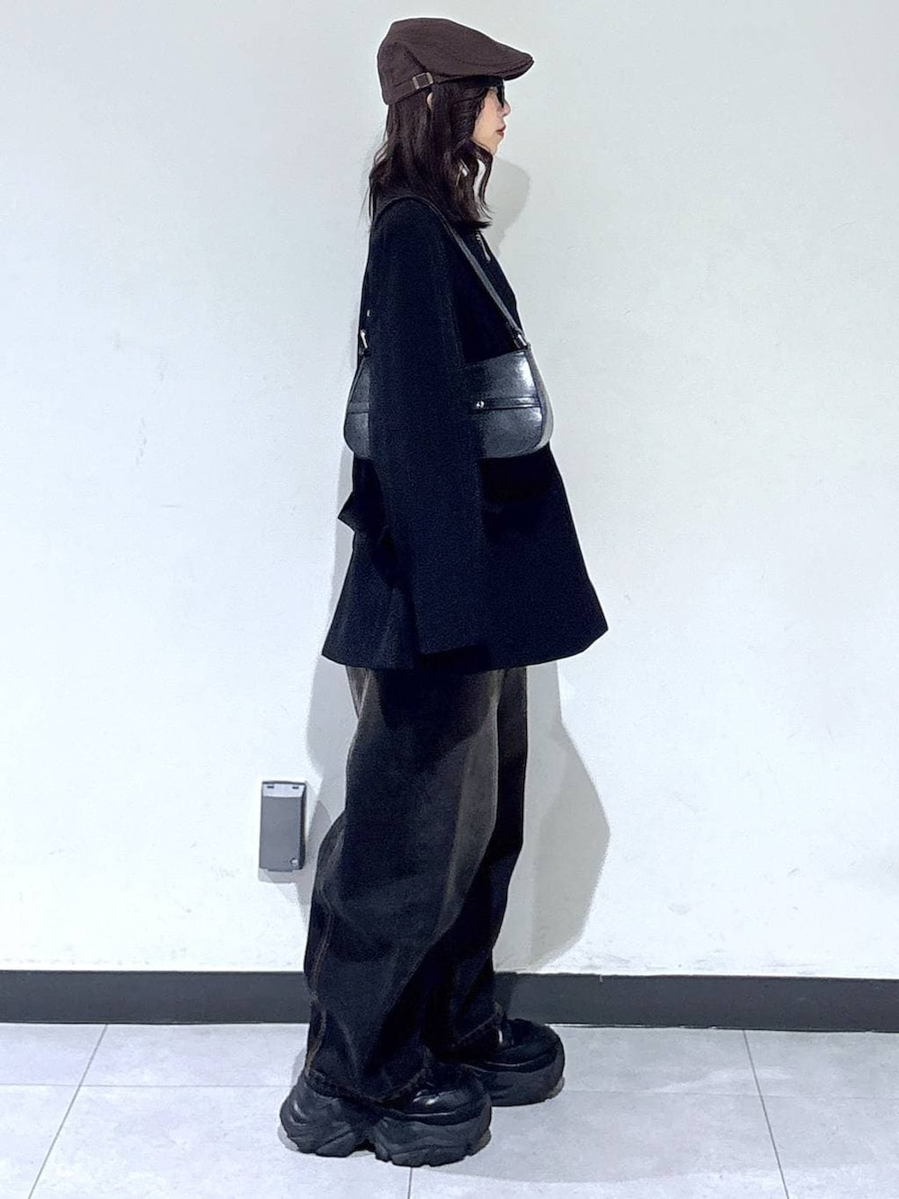 ブラック系のブーツ、ブラック系のTシャツ/カットソー、ブラック系のデニムパンツを着用したレディースの冬コーディネートの4枚目の写真