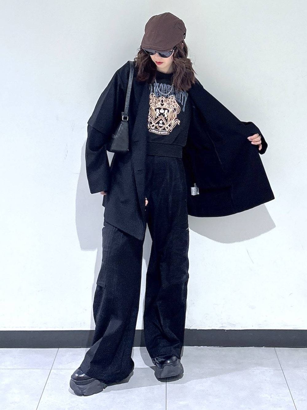 ブラック系のブーツ、ブラック系のハンドバッグ、グレー系のスウェットを着用したレディースの春コーディネートの4枚目の写真