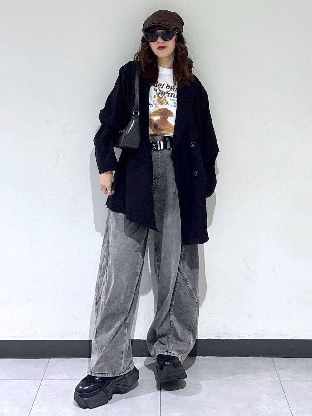 ブラック系のブーツ、ブラック系のハンドバッグ、ブラック系のテーラードジャケットを着用したレディースの春コーディネートの6枚目の写真