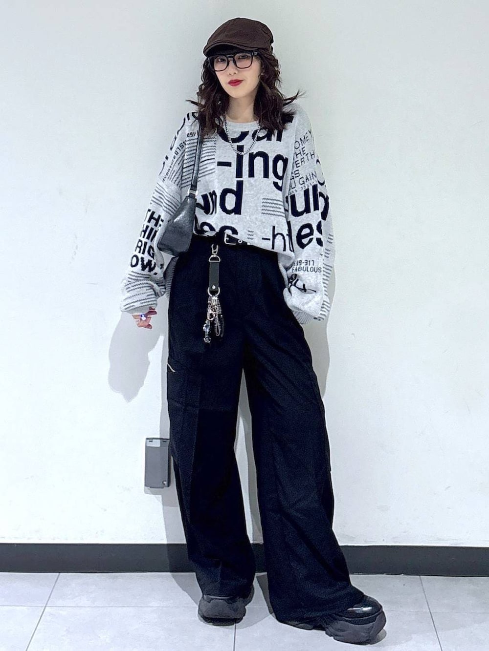 ブラック系のブーツ、ブラック系のハンドバッグ、グレー系のニット/セーターを着用したレディースの春コーディネートの5枚目の写真