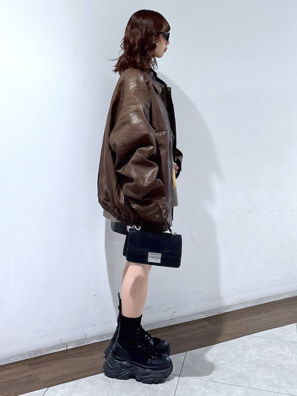 ブラック系のブーツ、ブラック系のハンドバッグ、ブラウン系のブルゾンを着用したレディースの秋コーディネートの2枚目の写真