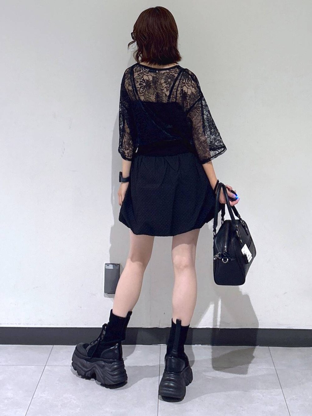 ブラック系のブーツ、ブラック系のTシャツ/カットソー、ブラック系のショルダーバッグを着用したレディースの夏コーディネートの6枚目の写真