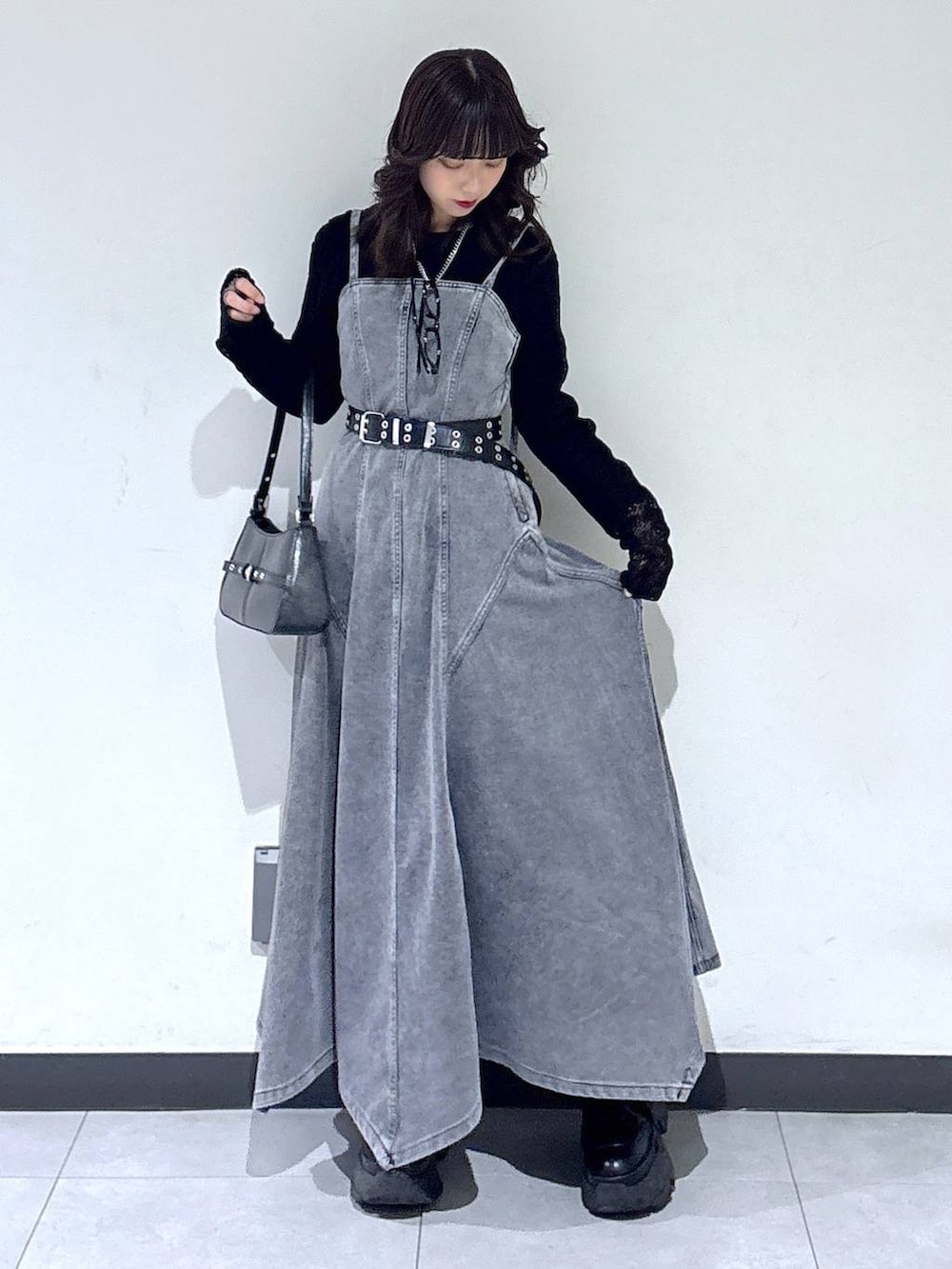 ブラック系のブーツ、ブラック系のTシャツ/カットソー、ブラック系のハンドバッグを着用したレディースの冬コーディネートの2枚目の写真