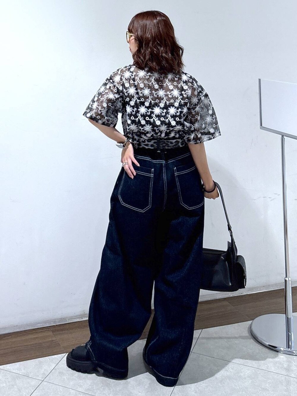 ブラック系のサンダル、ブルー系のデニムパンツ、ブラック系のシャツ/ブラウスを着用したレディースの夏コーディネートの6枚目の写真