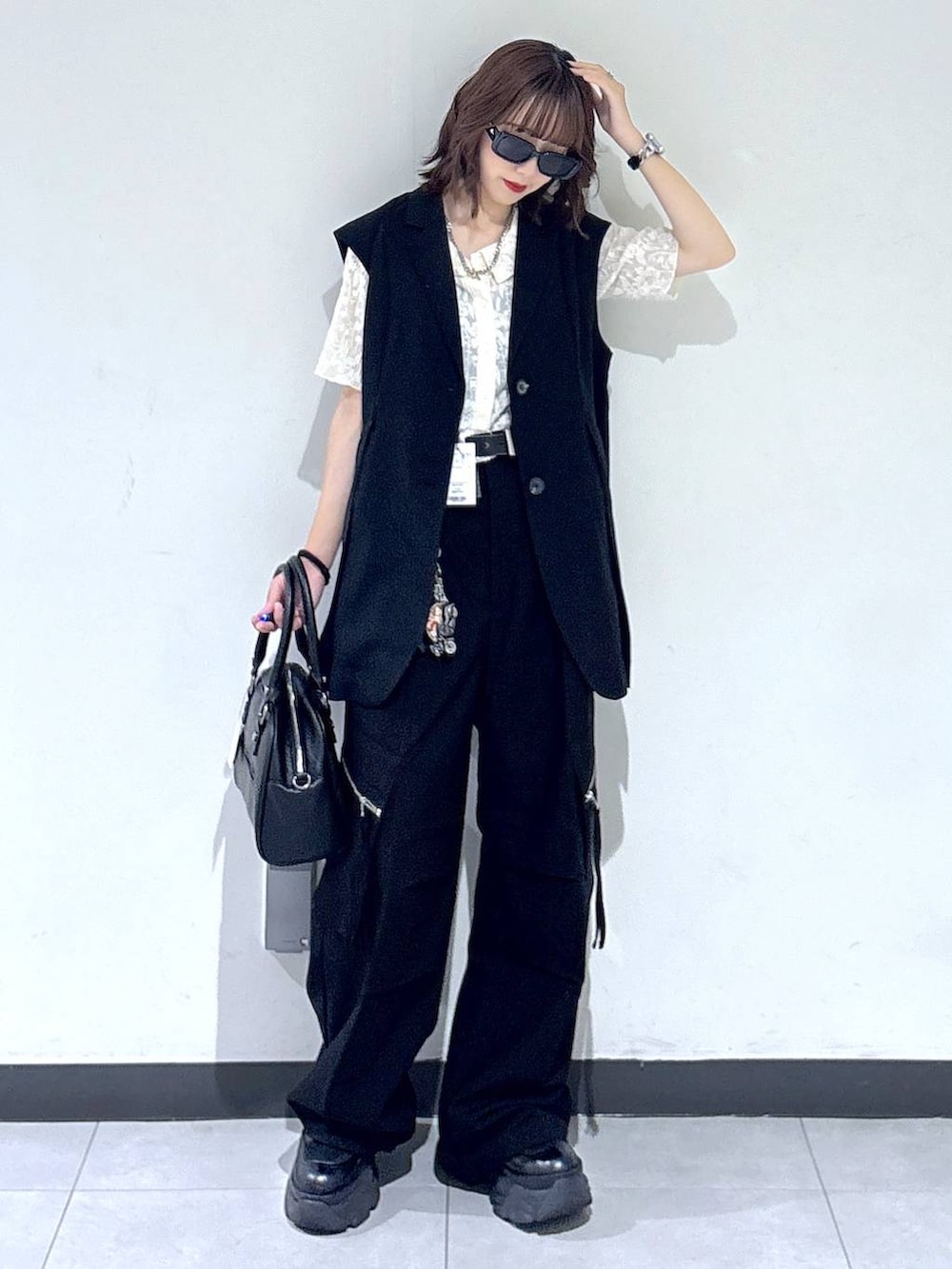 ブラック系のブーツ、ブラック系のカーゴパンツ、ブラック系のベストを着用したレディースの夏コーディネートの7枚目の写真