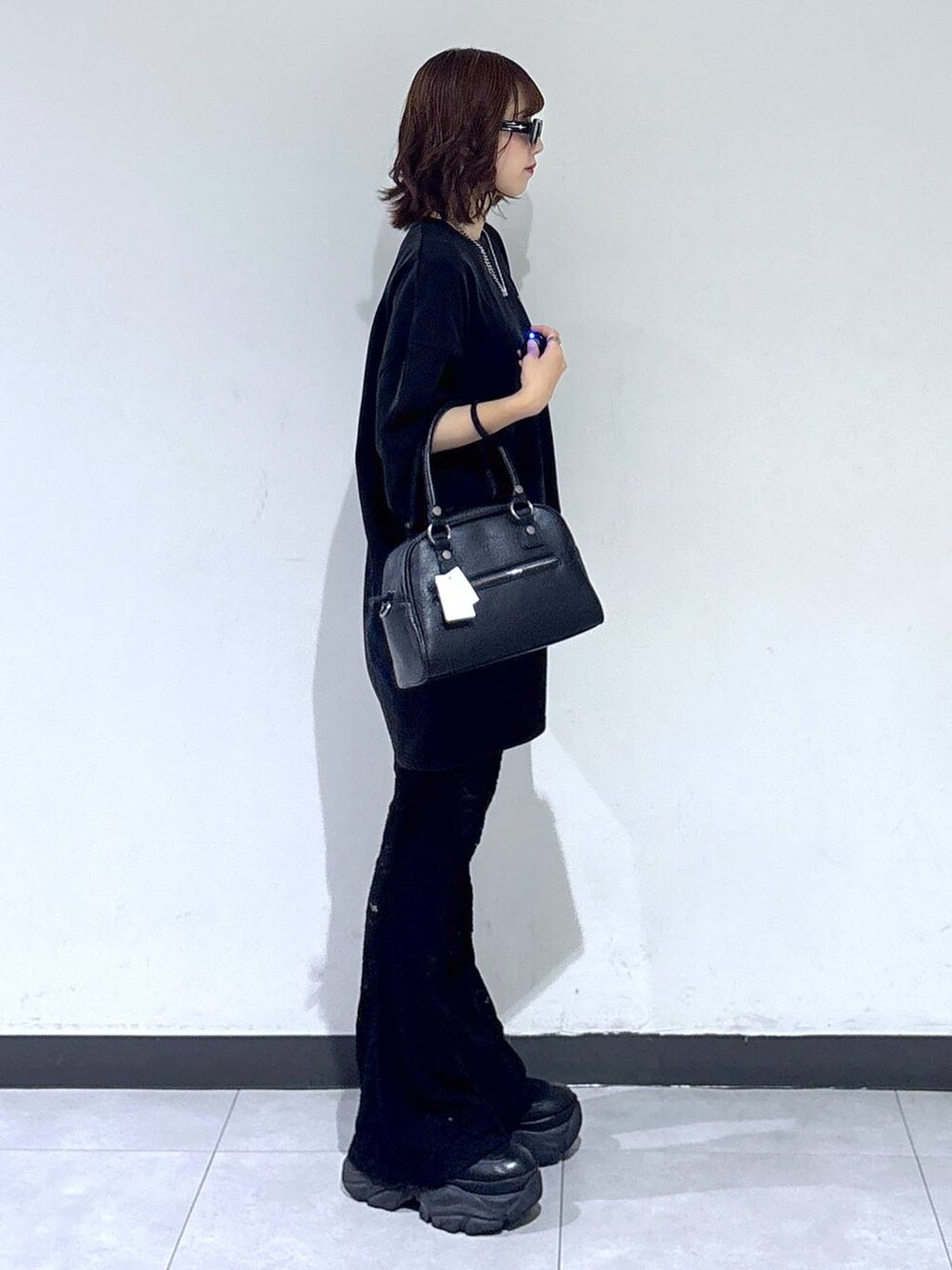 ブラック系のブーツ、ブラック系のその他パンツ、ブラック系のショルダーバッグを着用したレディースの夏コーディネートの3枚目の写真