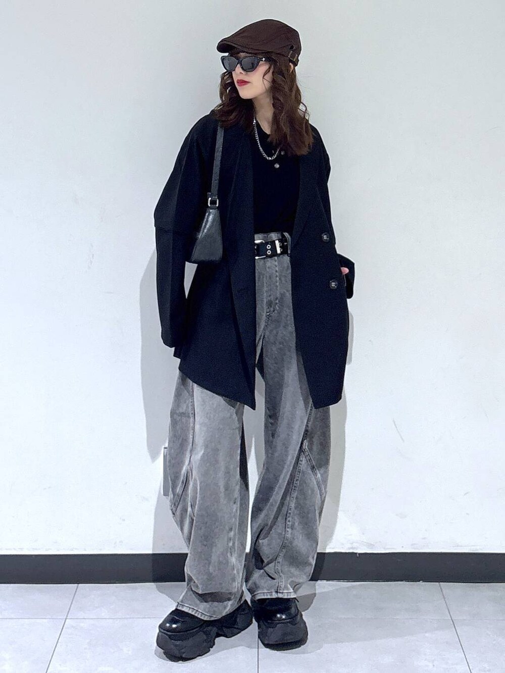 ブラック系のブーツ、ブラック系のハンドバッグ、ブラック系のニット/セーターを着用したレディースの春コーディネートの2枚目の写真