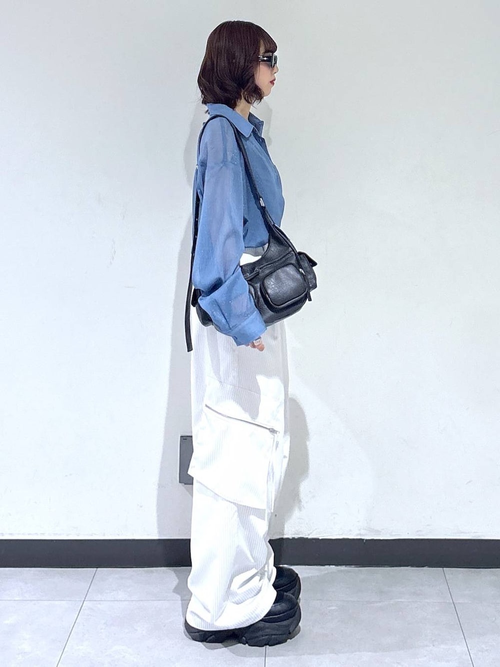 ブラック系のブーツ、ホワイト系のカーゴパンツ、ブルー系のシャツ/ブラウスを着用したレディースの夏コーディネートの3枚目の写真