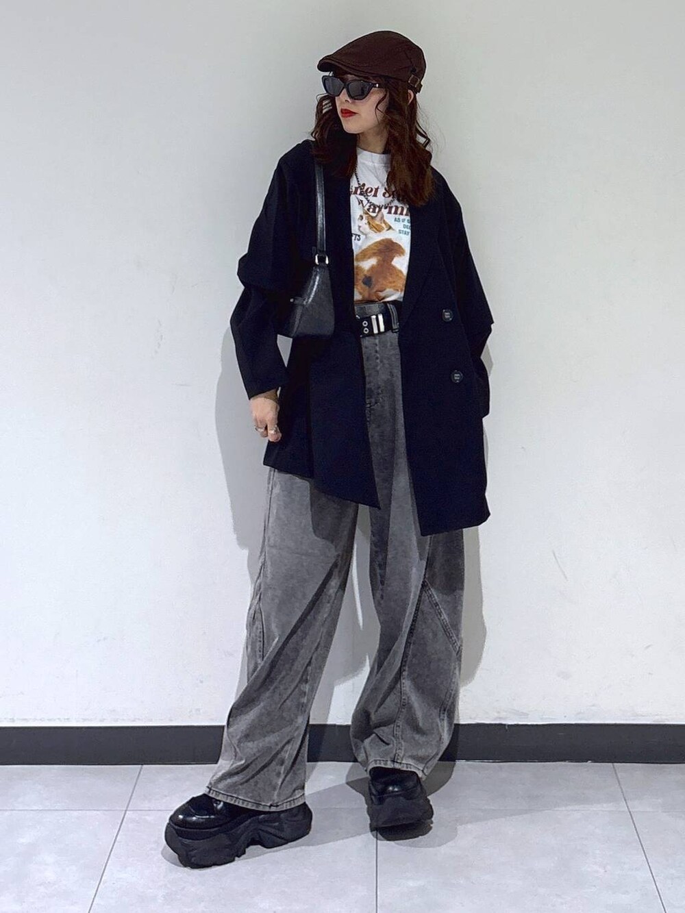 ブラック系のブーツ、ブラック系のハンドバッグ、ブラック系のテーラードジャケットを着用したレディースの春コーディネートの5枚目の写真