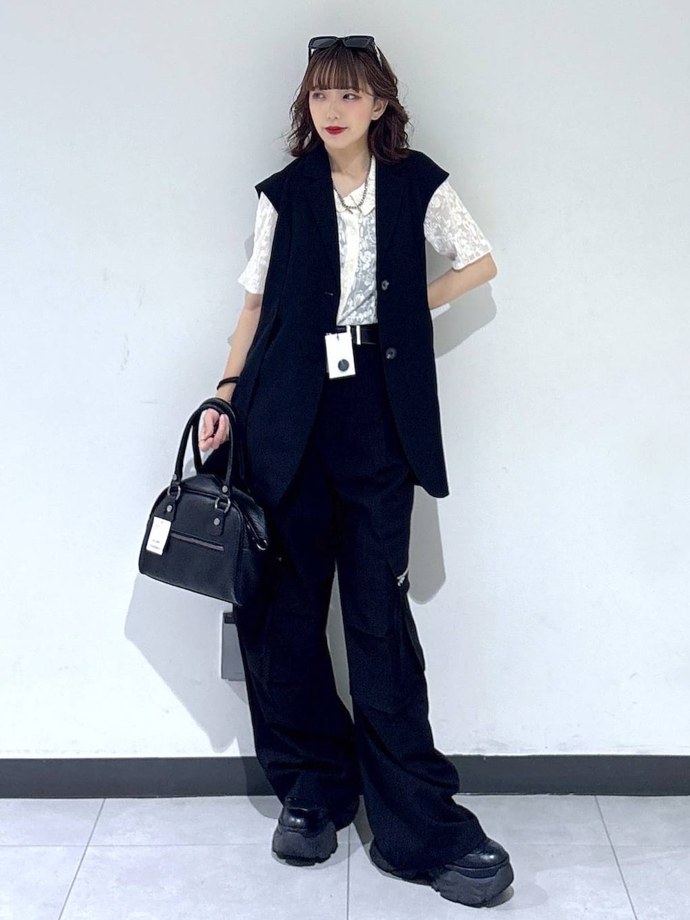 ブラック系のブーツ、ブラック系のカーゴパンツ、ブラック系のベストを着用したレディースの夏コーディネートの2枚目の写真