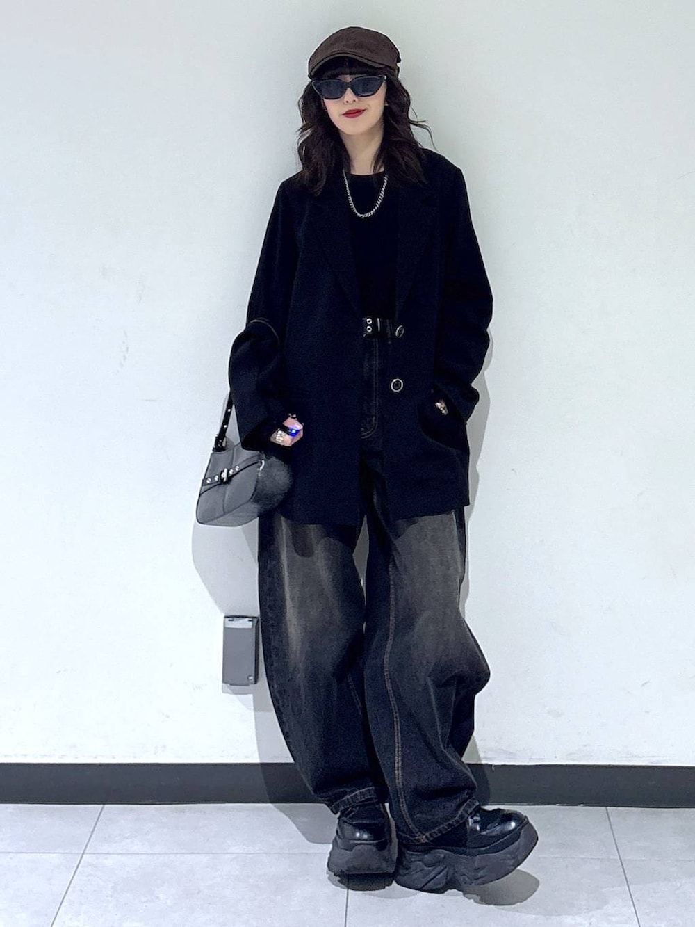 ブラック系のブーツ、ブラック系のTシャツ/カットソー、ブラック系のデニムパンツを着用したレディースの冬コーディネートの6枚目の写真