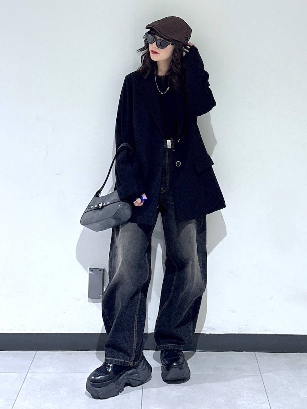 ブラック系のブーツ、ブラック系のTシャツ/カットソー、ブラック系のデニムパンツを着用したレディースの冬コーディネートの3枚目の写真