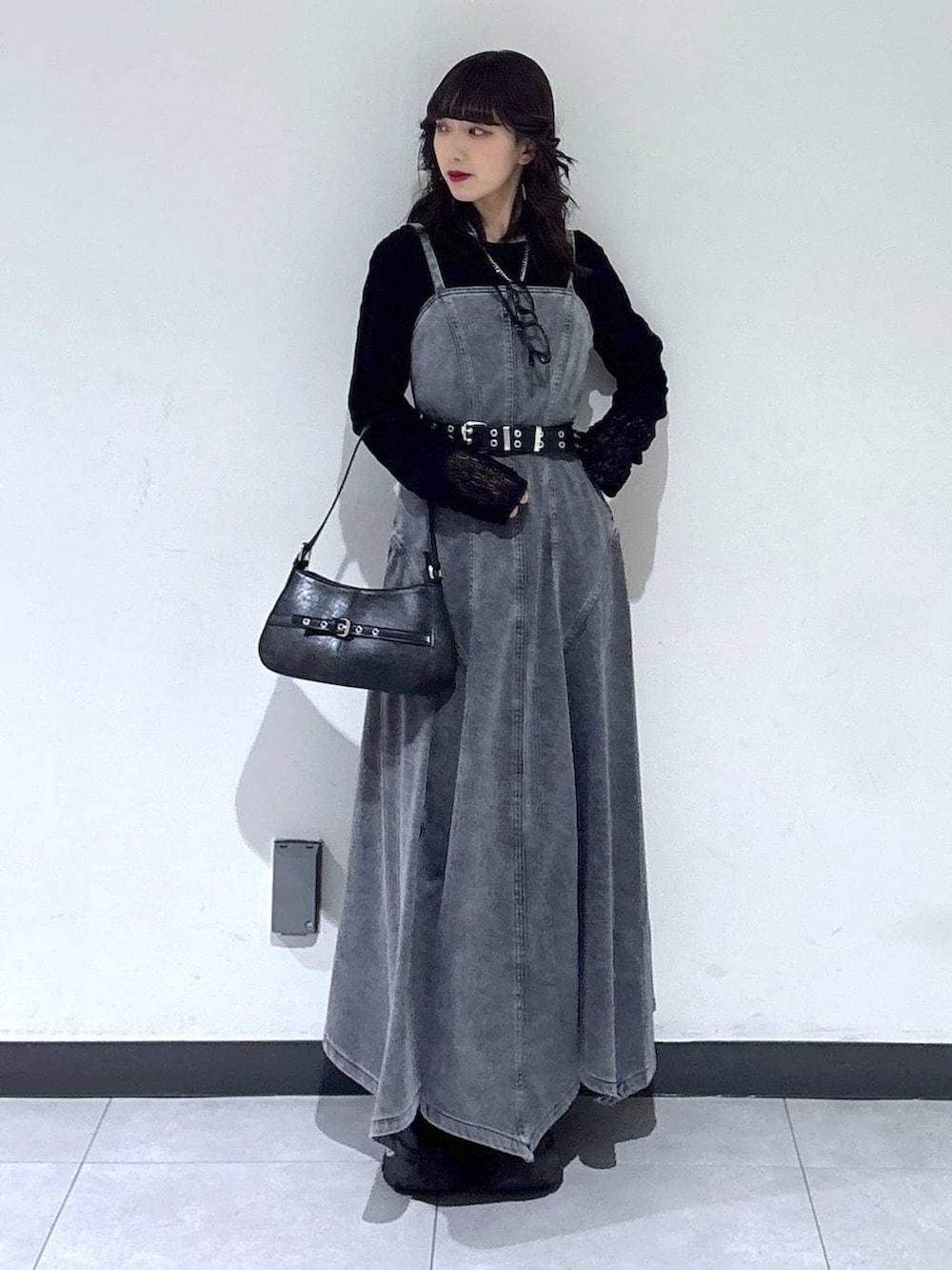 ブラック系のブーツ、ブラック系のTシャツ/カットソー、ブラック系のハンドバッグを着用したレディースの冬コーディネートの3枚目の写真