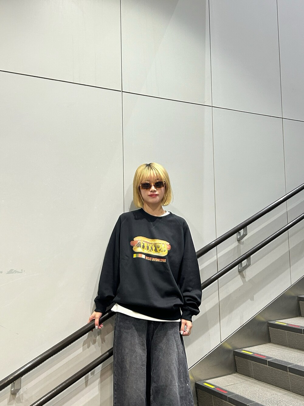 ブラック系のスウェット、ブラック系のデニムパンツを着用したレディースの秋コーディネートの2枚目の写真