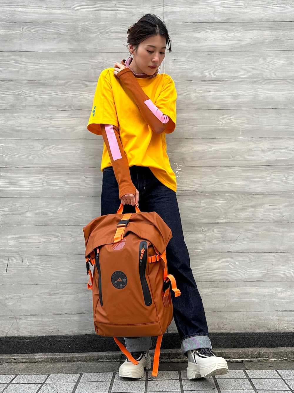 ブラウン系のTシャツ/カットソー、イエロー系のTシャツ/カットソー、ブラウン系のバックパック/リュックを着用したレディースの秋コーディネートの2枚目の写真