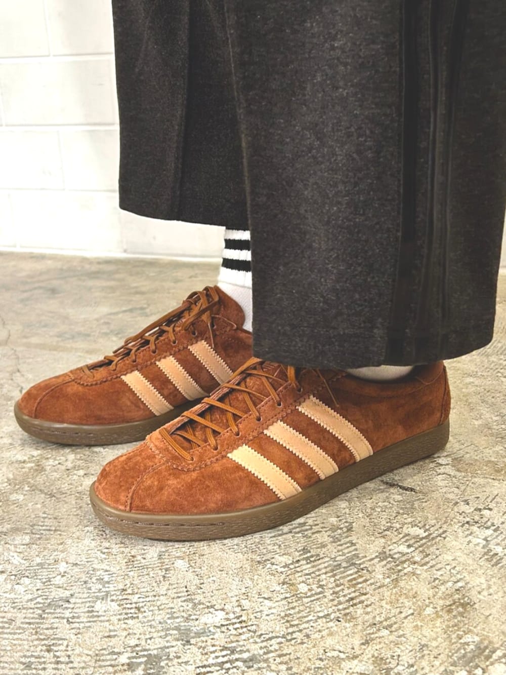 ホワイト系のジャージ、ブラック系のスウェットパンツ、ブラウン系のスニーカーを着用したメンズの秋コーディネートの2枚目の写真