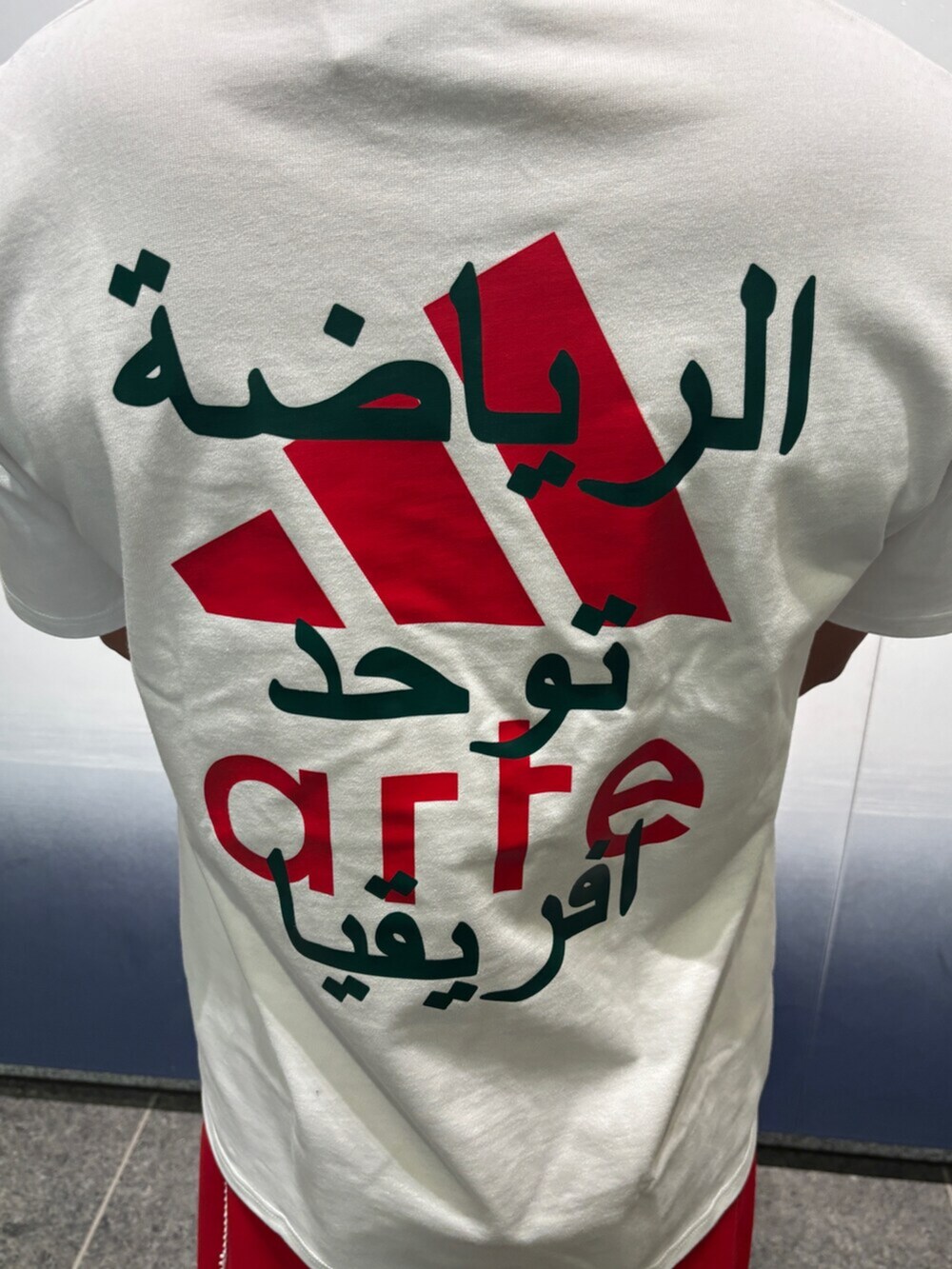 レッド系のトップス、ホワイト系のトップス、レッド系のパンツを着用したメンズの冬コーディネートの4枚目の写真