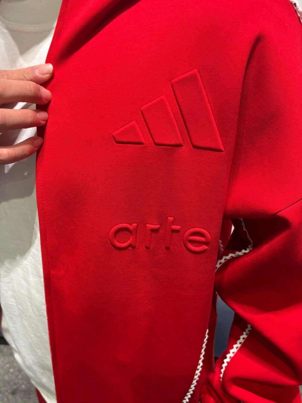 レッド系のトップス、ホワイト系のトップス、レッド系のパンツを着用したメンズの冬コーディネートの3枚目の写真